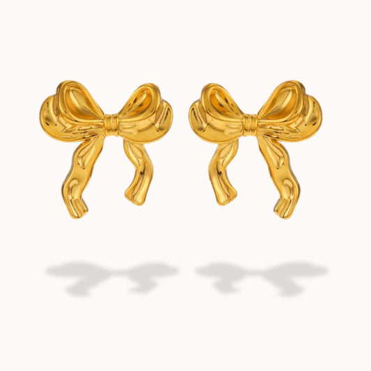 Gold bow-shaped earrings on a white background