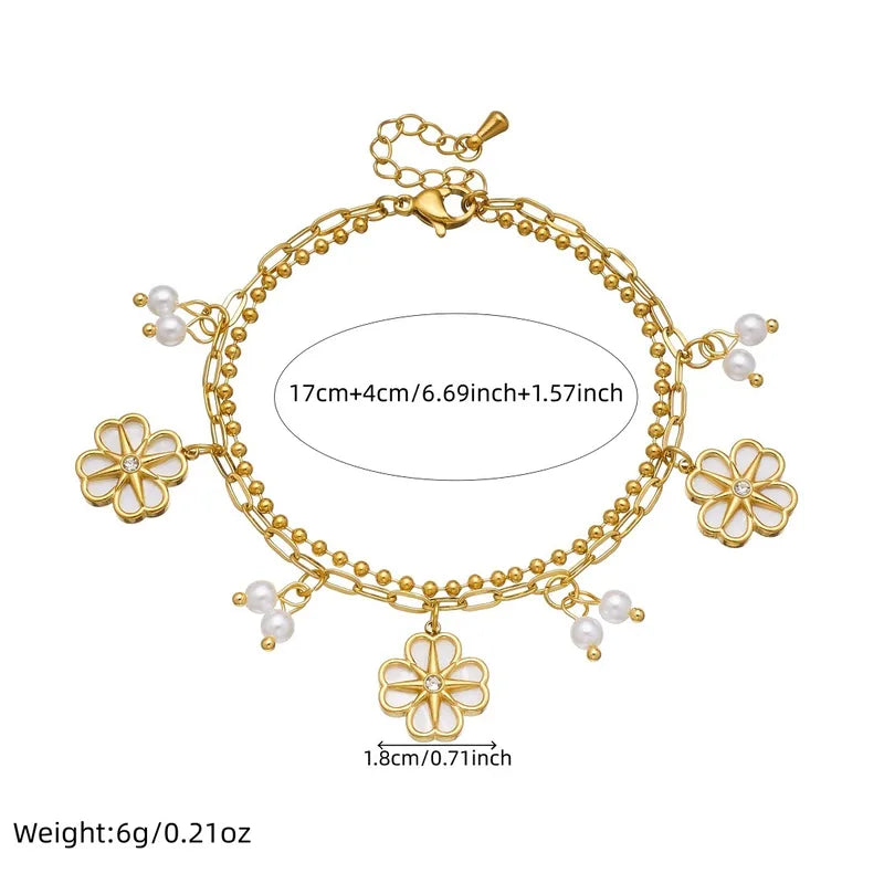 Gold bracelet with floral charms and measurements on a white background