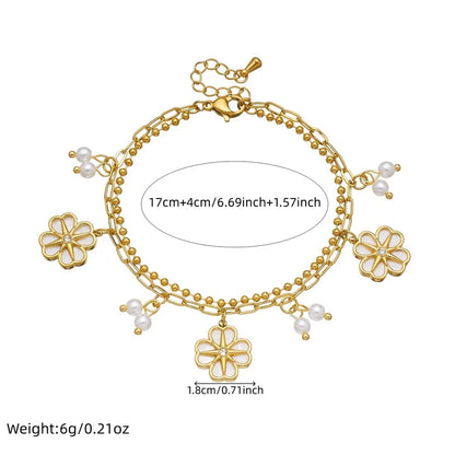 Gold bracelet with floral charms and measurements on a white background