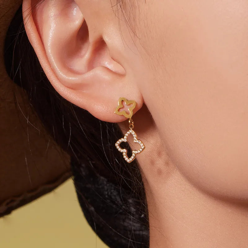 Close-up of a person wearing gold earrings with a blurred background