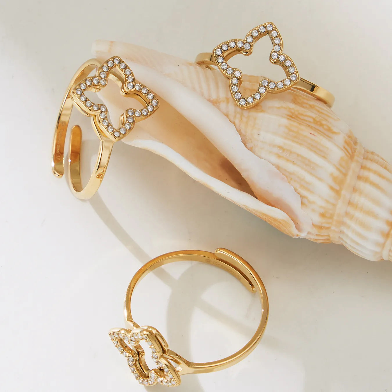 Gold open ring with bow design on a white background