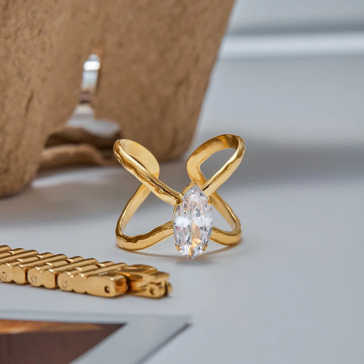 Gold ring with a clear gemstone on a light surface