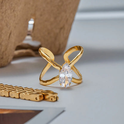 Gold ring with a clear gemstone on a light surface