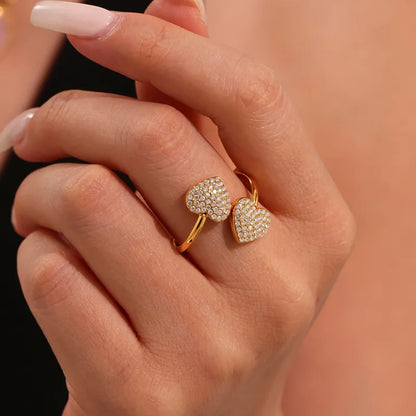Heart-shaped diamond ring on a hand against a neutral background