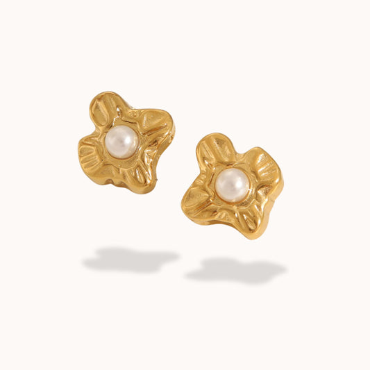 Gold earrings with pearl centers on a white background