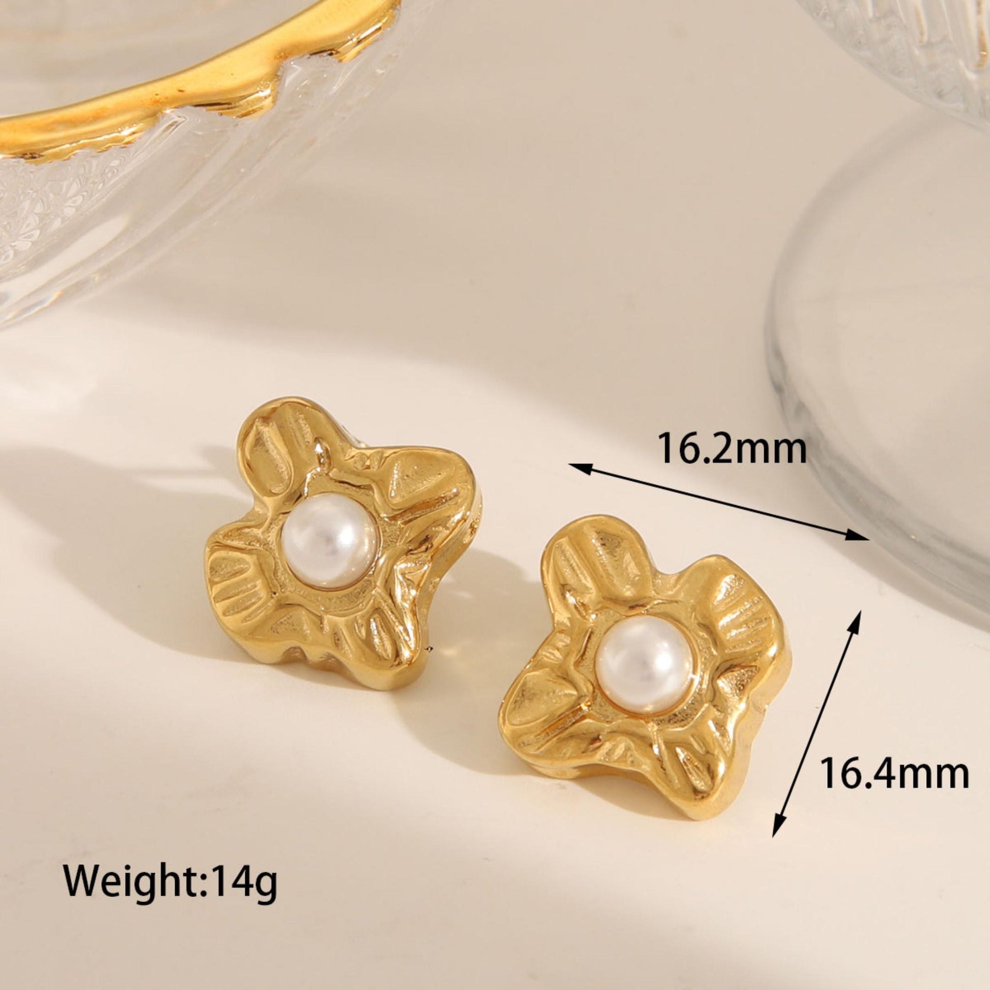 Gold floral earrings with pearl center on a light background, showing measurements and weight.