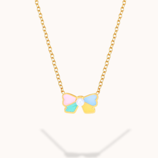 Bow-shaped pendant on a gold chain against a white background