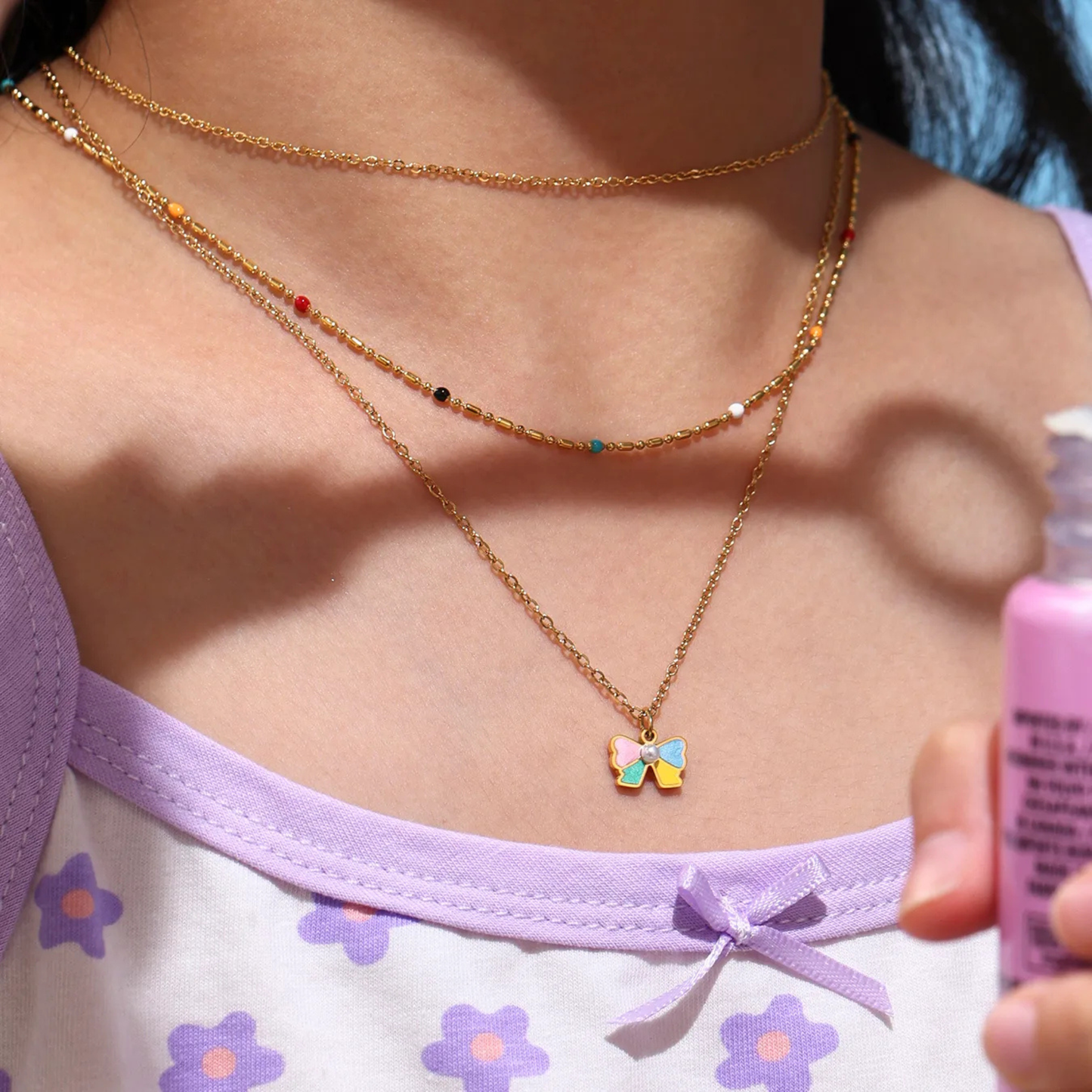 Person wearing a colorful bow necklace with a blurred background