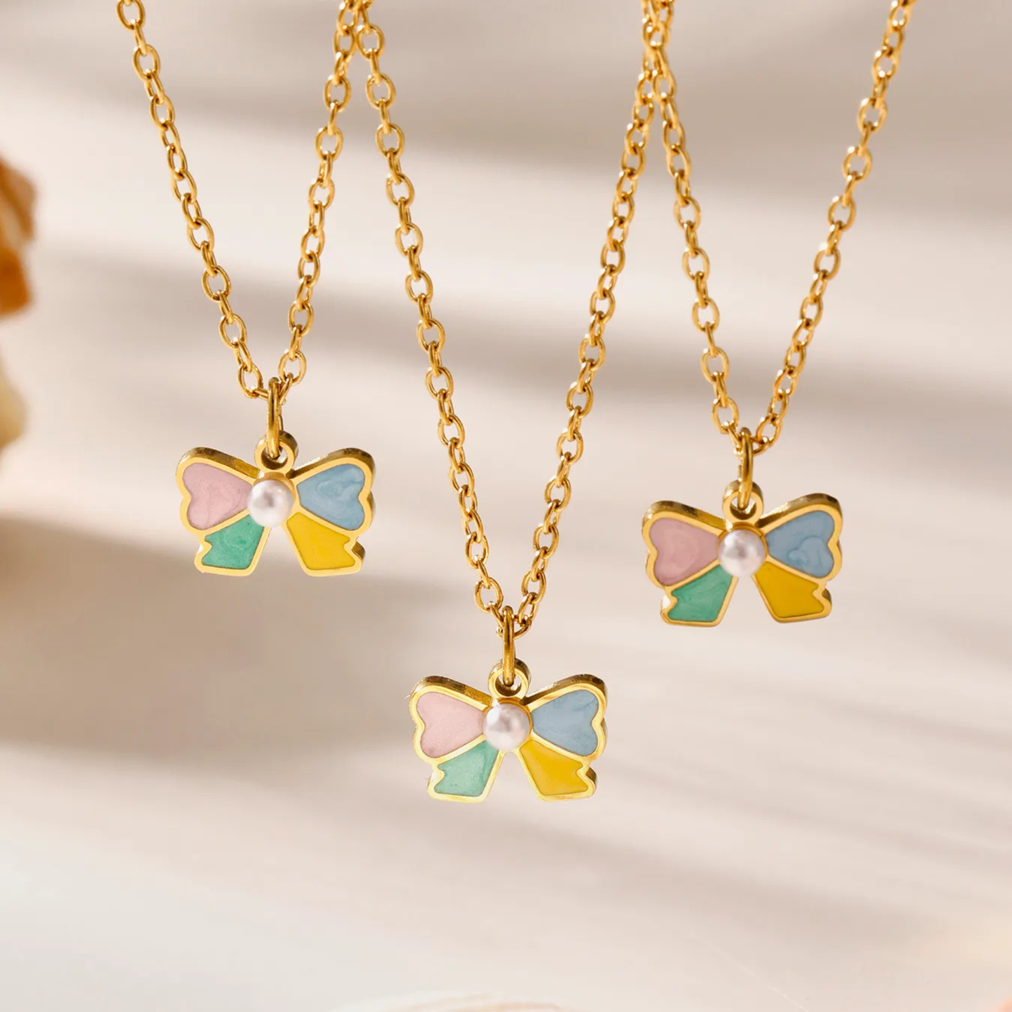 bow-shaped jewelry set with gold chains on a soft background