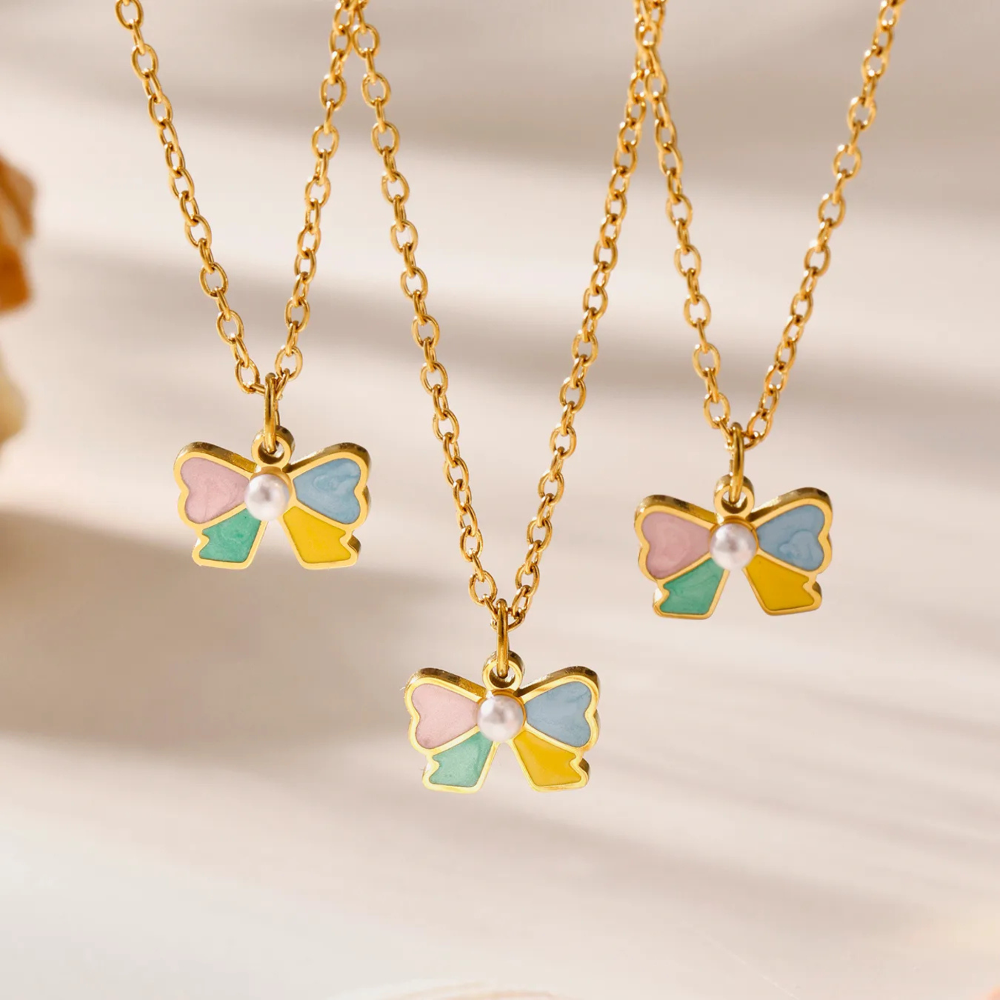 bow-shaped jewelry set with gold chains on a soft background