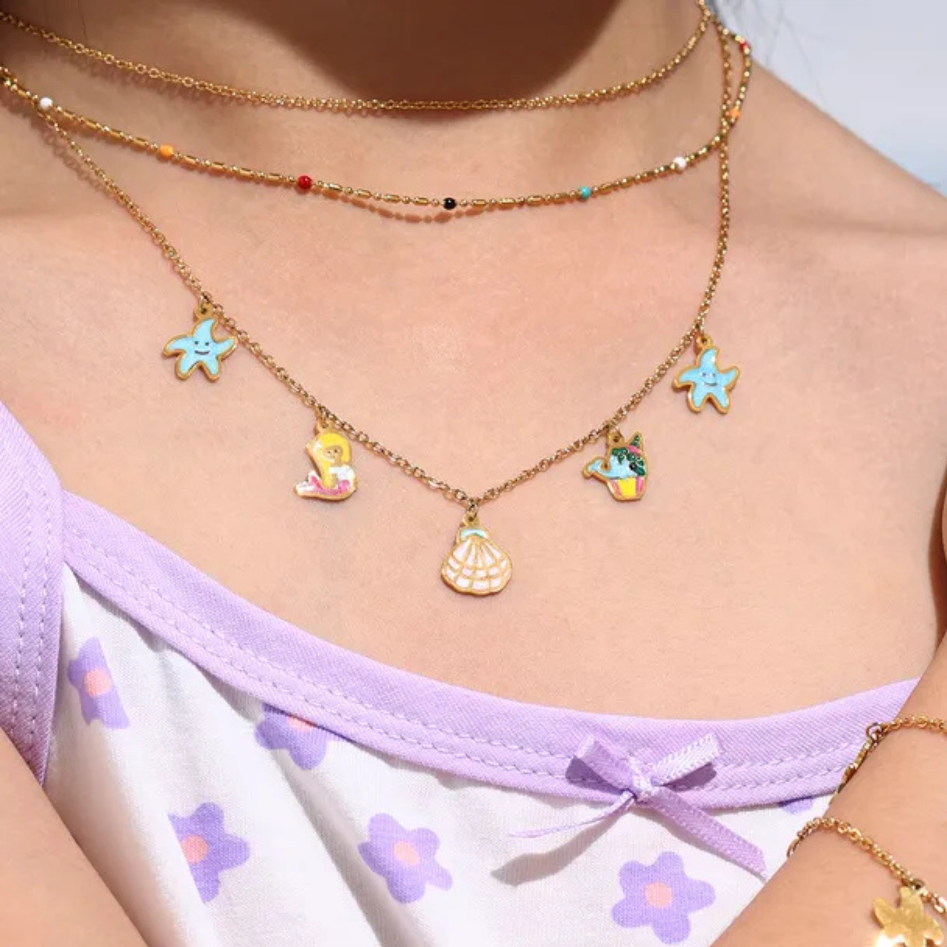 Necklace with colorful charms worn by a person, with a focus on the jewelry.