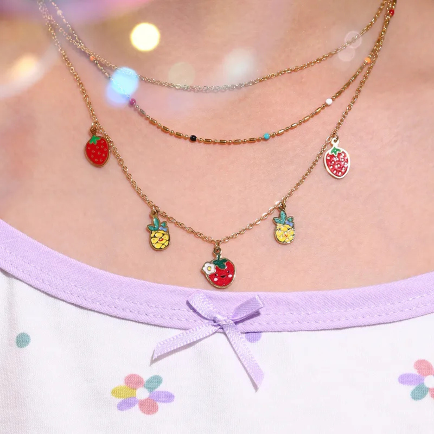 Necklace with fruit charms worn by a person, with a blurred background