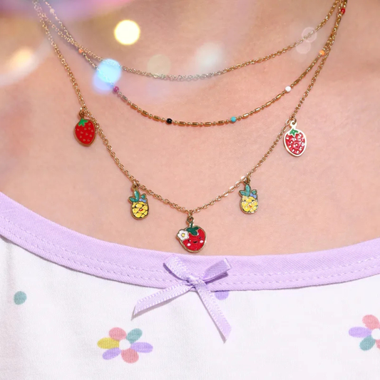 Necklace with fruit charms worn by a person, with a blurred background