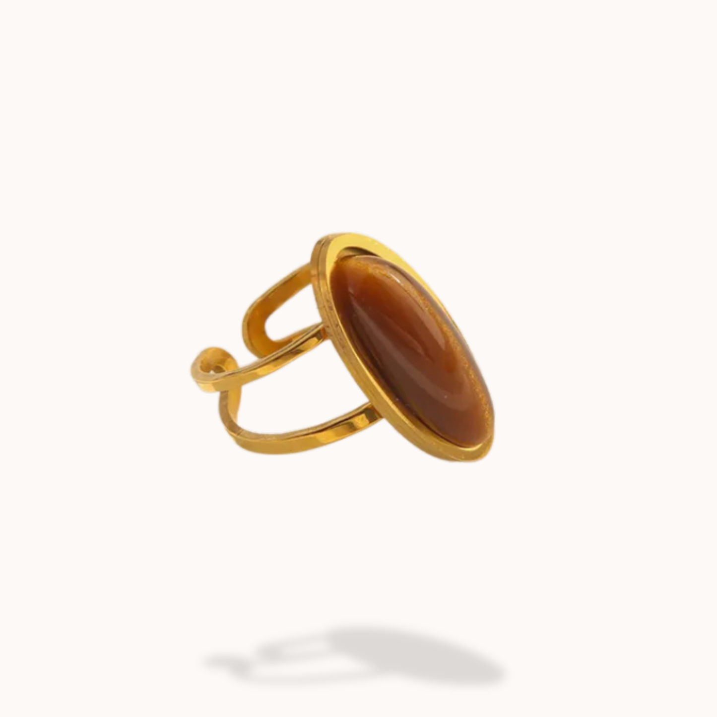 Gold ring with a brown stone on a white background
