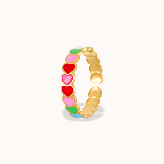 Gold ring with colorful heart-shaped enamel on a white background