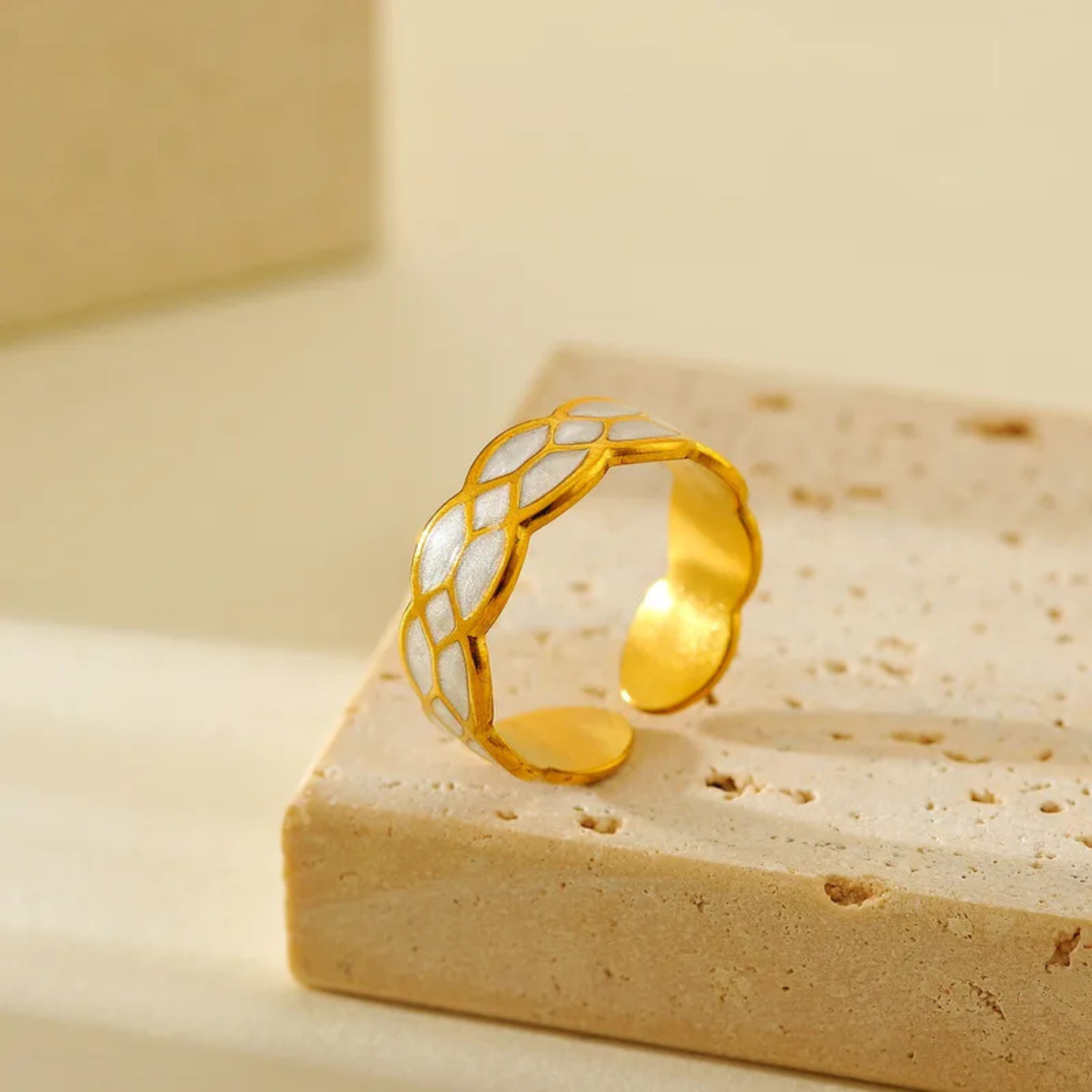 Gold ring with white pattern on a white background