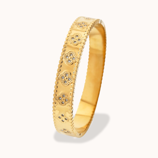Gold bracelet with decorative elements on a white background