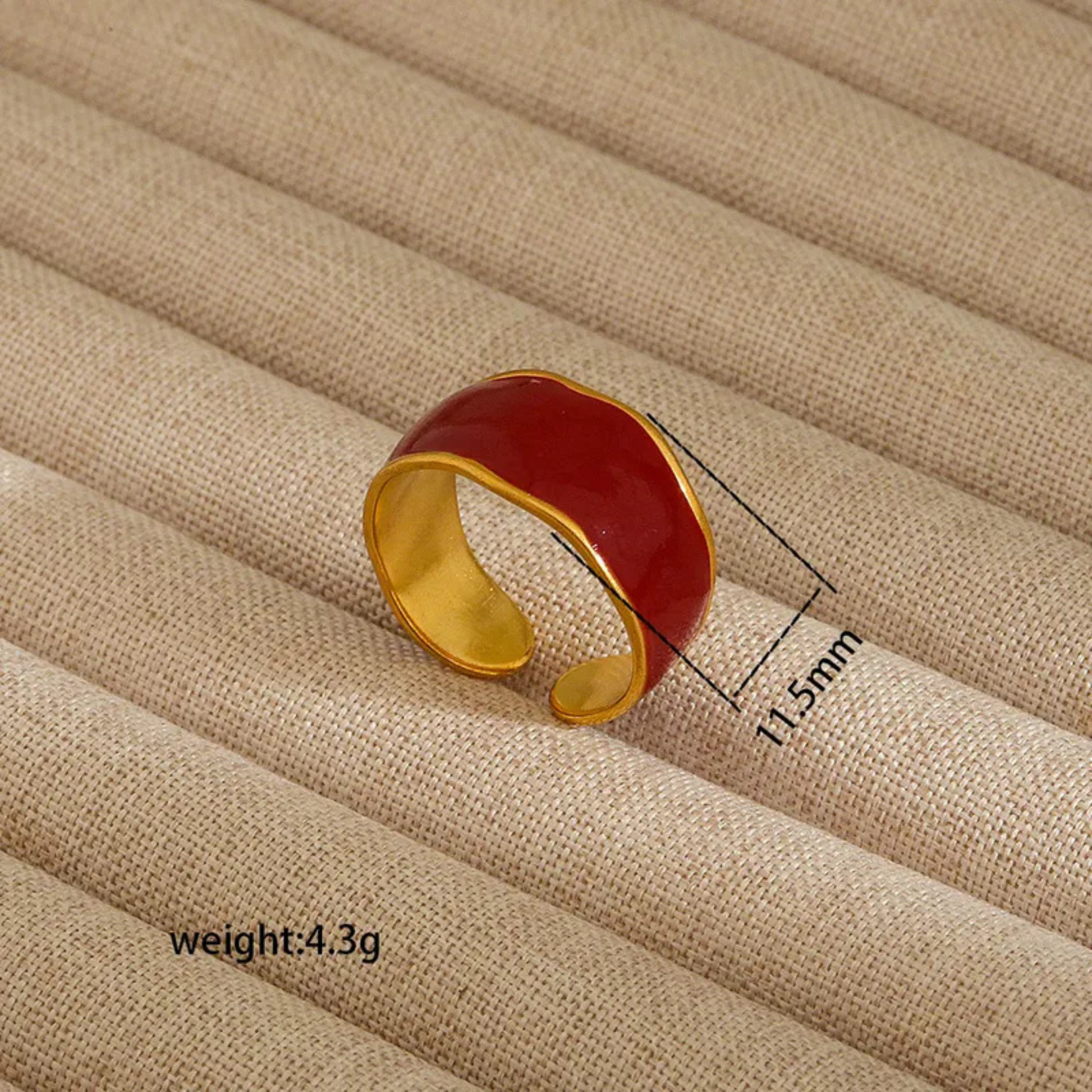 Red and gold ring on beige fabric with measurements and weight displayed