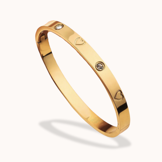 Gold bracelet with heart and diamond designs on a white background