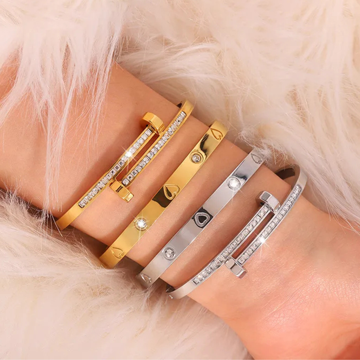 Gold and silver bracelets on a wrist with a fur background