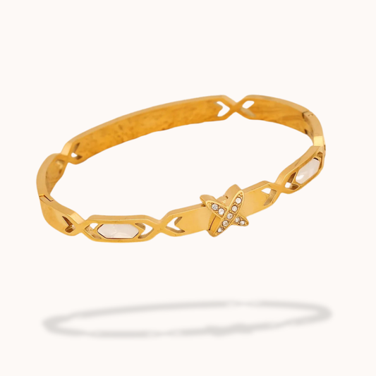 Gold bracelet with intricate design on a white background