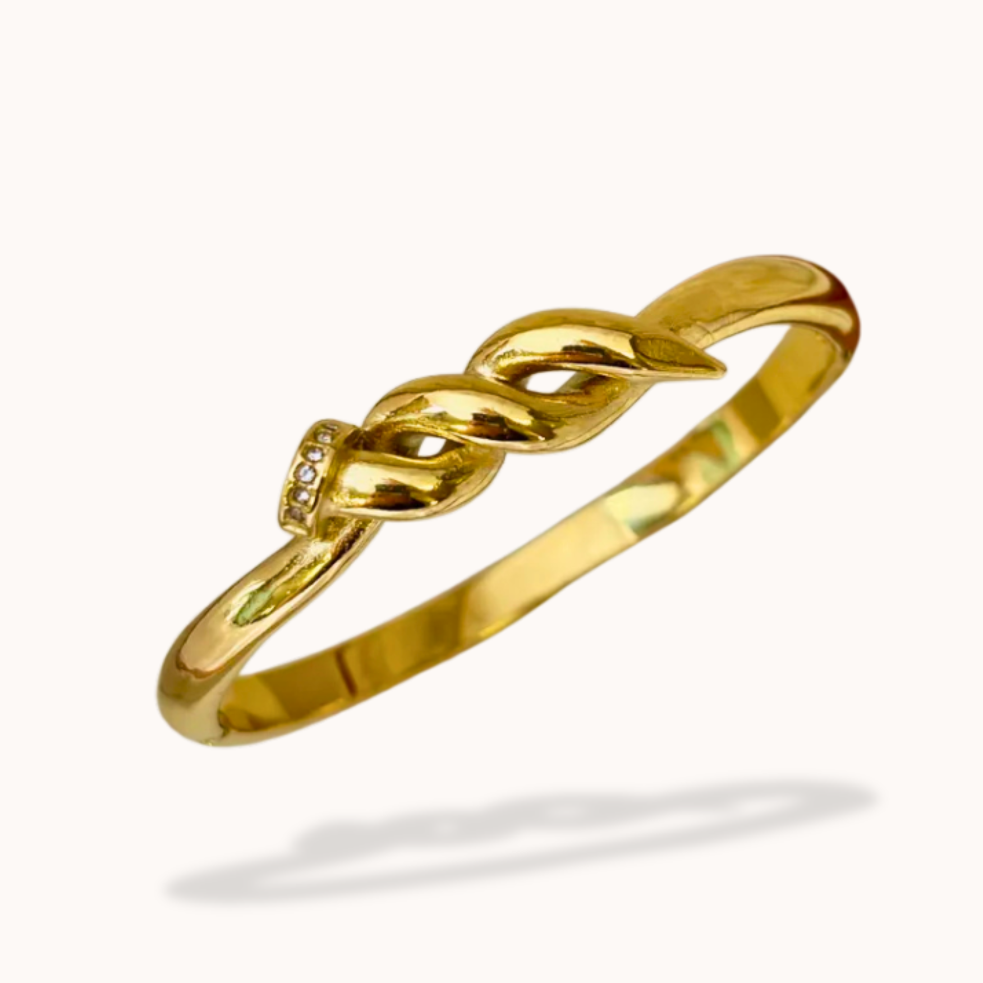 Gold bracelet with a knot design on a white background