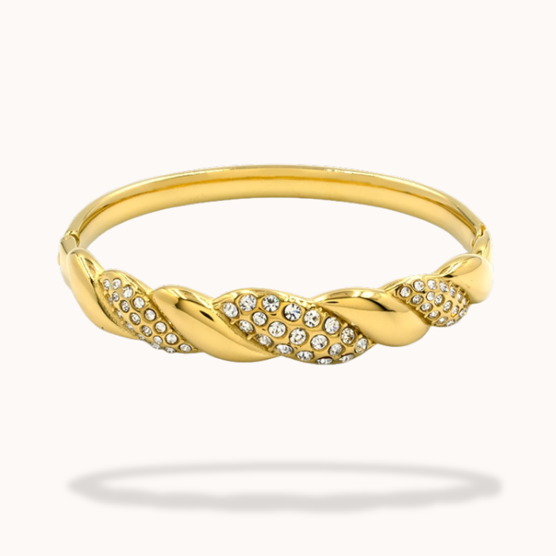 Gold bracelet with braided design and embedded crystals on a white background
