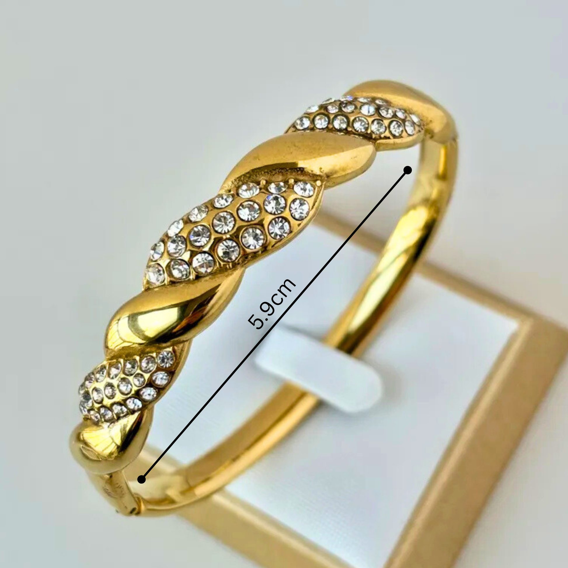 Gold bracelet with crystal embellishments on a white background