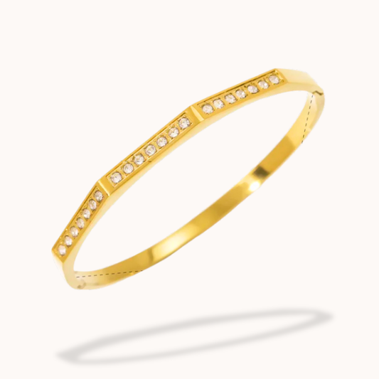 Gold bracelet with embedded diamonds on a white background