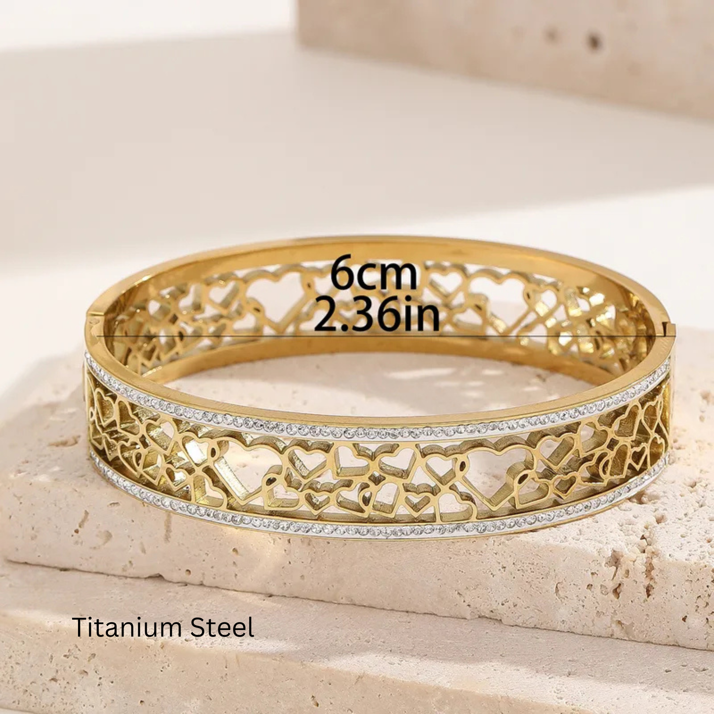 Gold bracelet with intricate design on a light stone surface, showing measurements and material type.