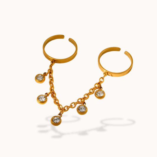 Gold hoop ringwith chain and gemstone drops on a white background