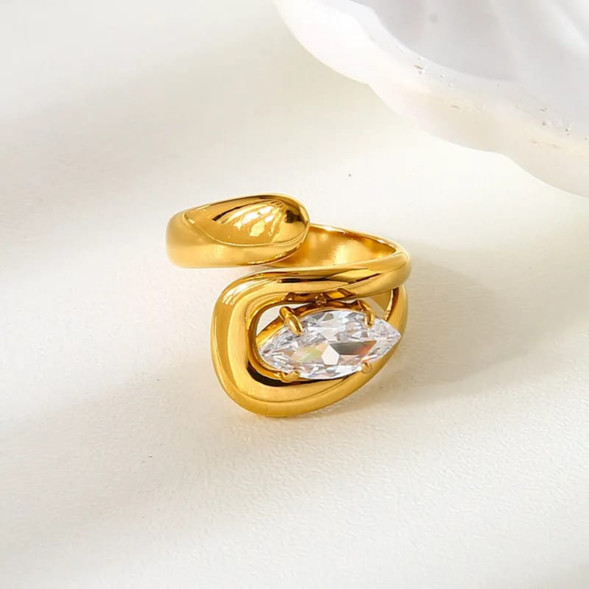 Gold ring with a clear gemstone on a white background