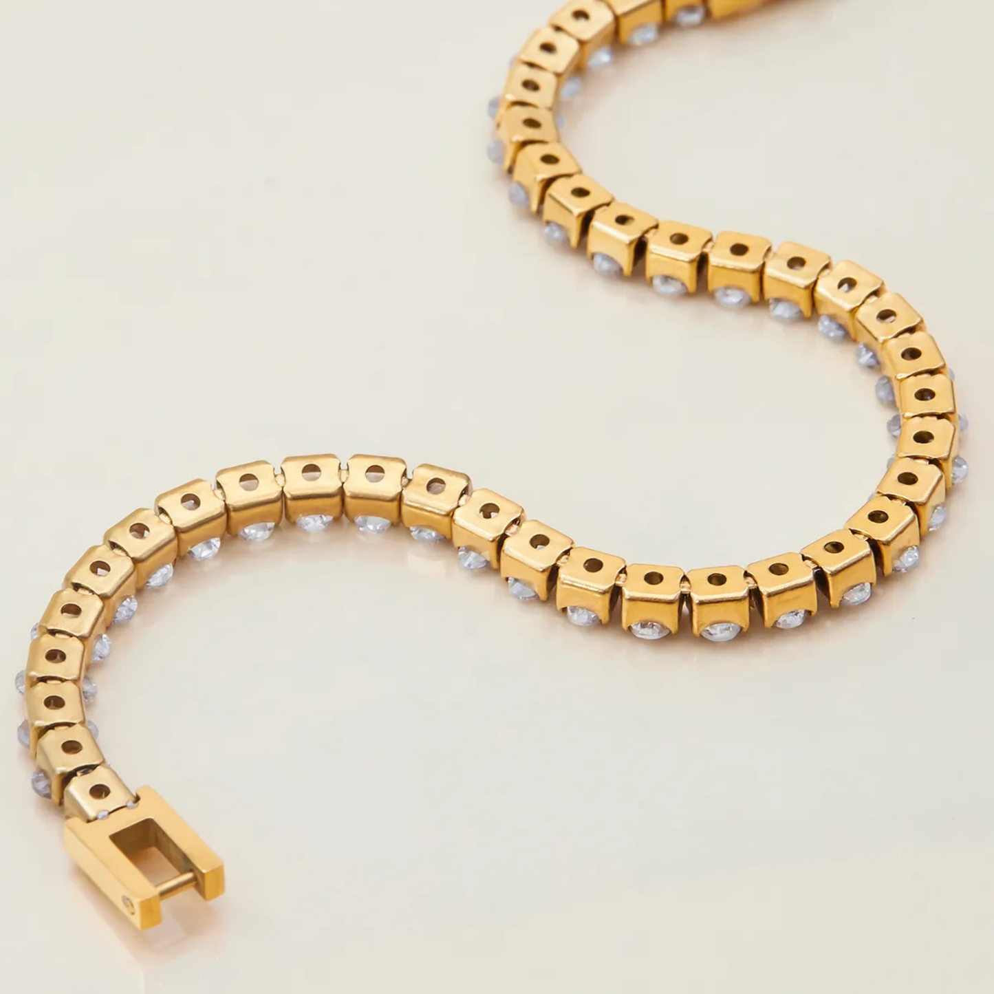 Gold bracelet with a heart-shaped design on a light background