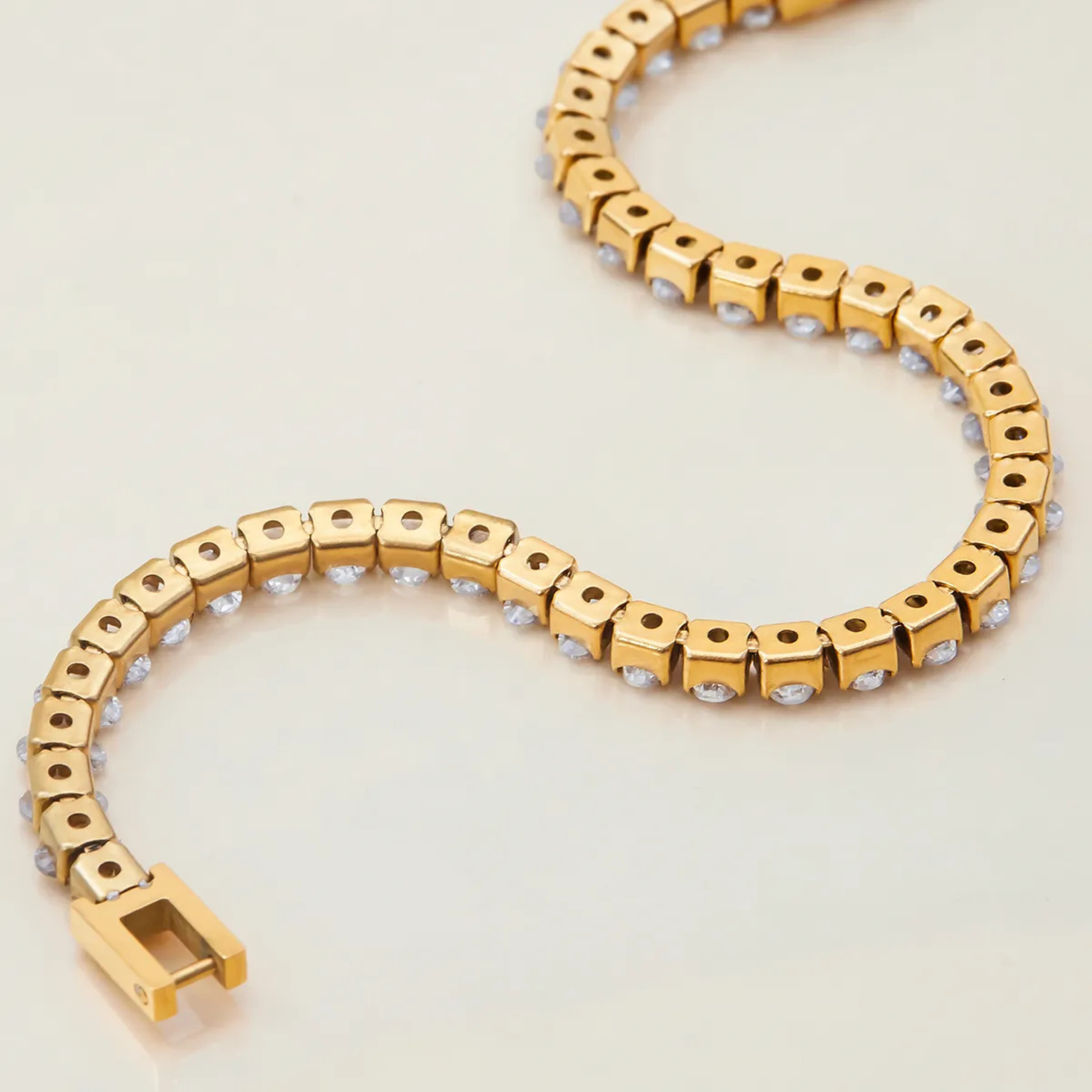 Gold bracelet with a heart-shaped design on a light background