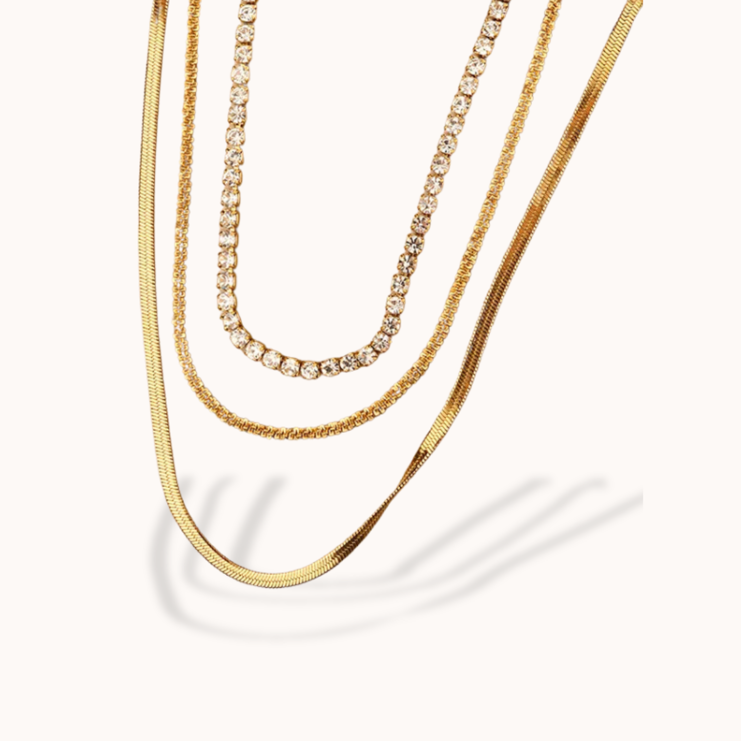 Three gold necklaces on a white background