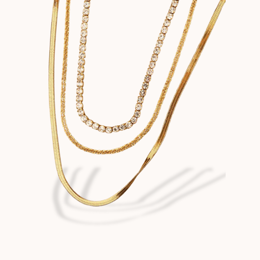 Three gold necklaces on a white background
