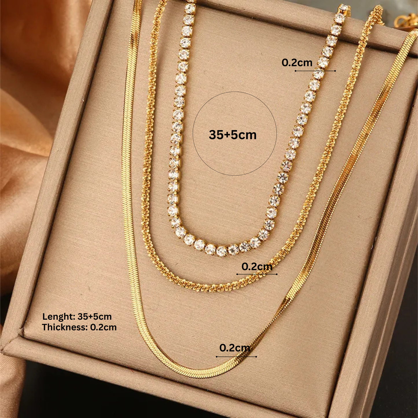 Gold necklaces with measurements on a beige background