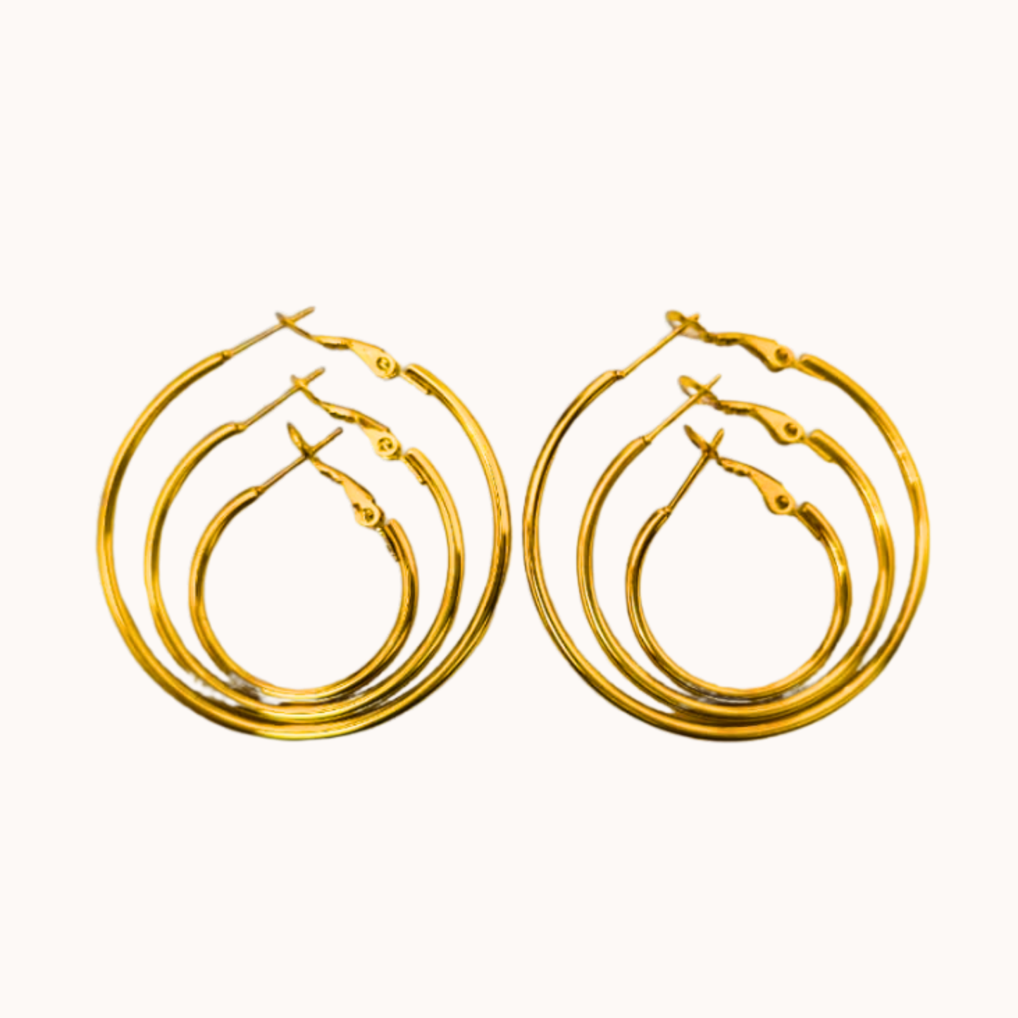 Set of gold hoop earrings on a white background