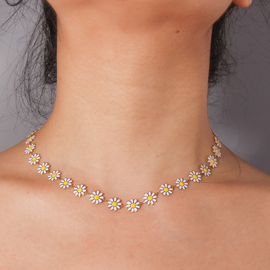 Necklace with daisy flower pendants on a person against a neutral background