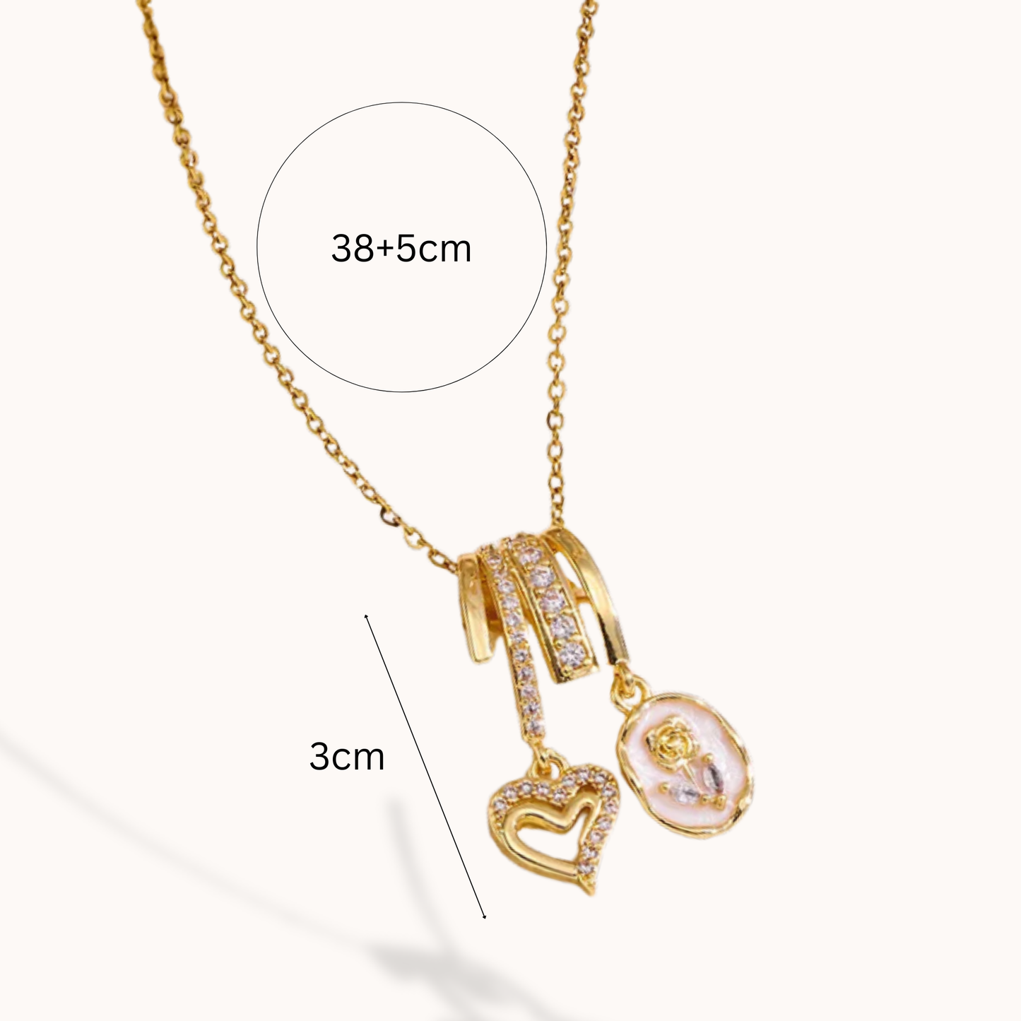 Gold necklace with heart and round pendant, showing measurements on a white background
