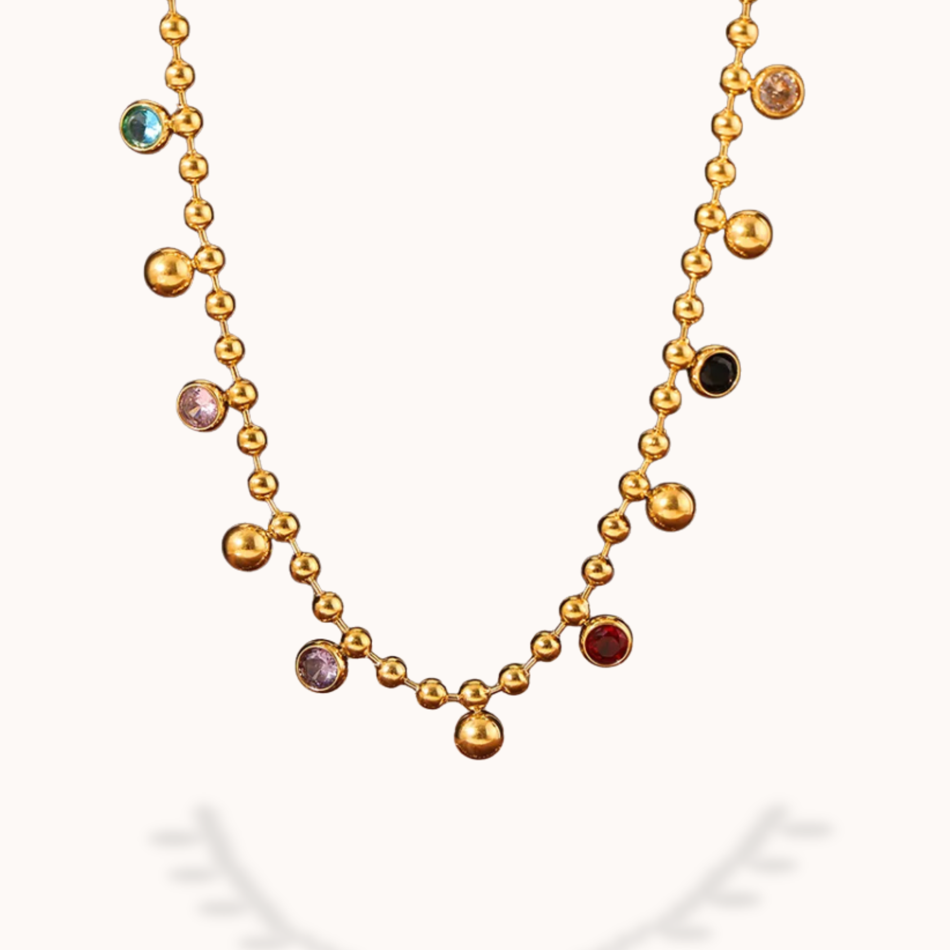 Gold necklace with colored beads on a white background