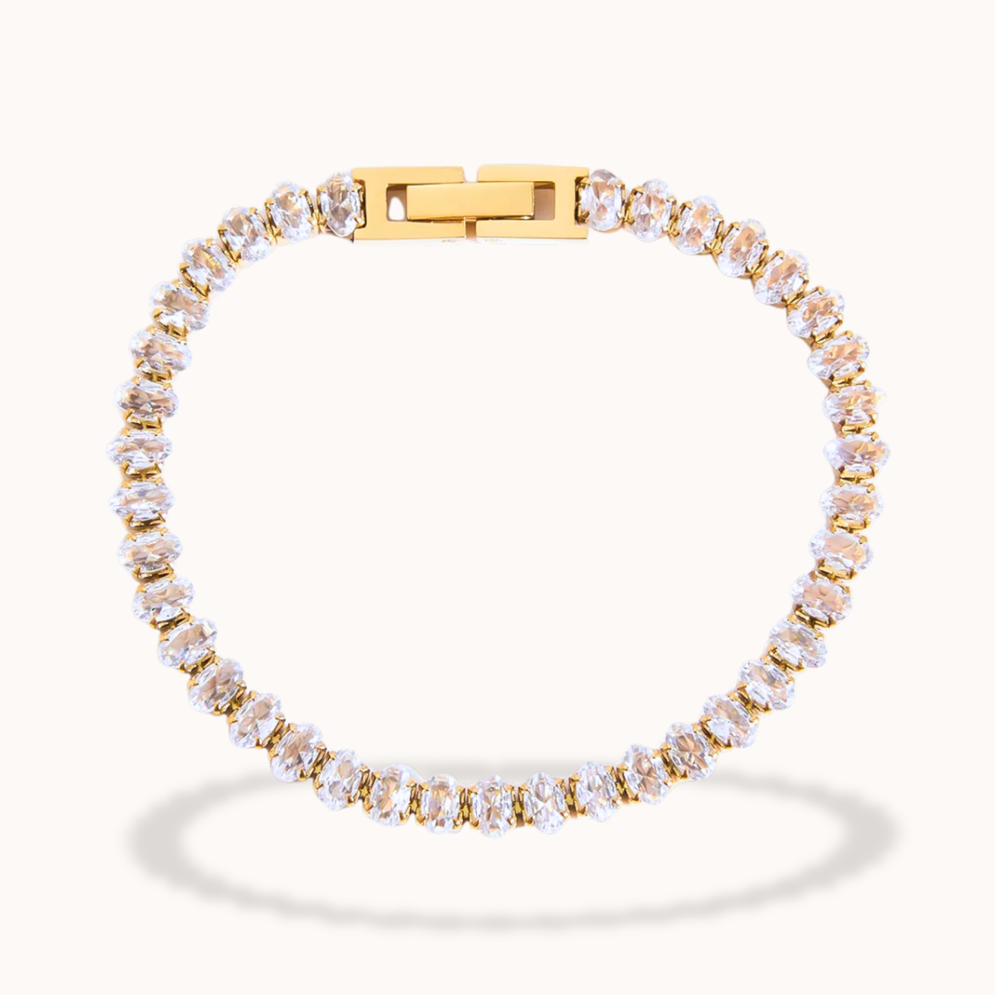 Gold bracelet with clear stones on a white background