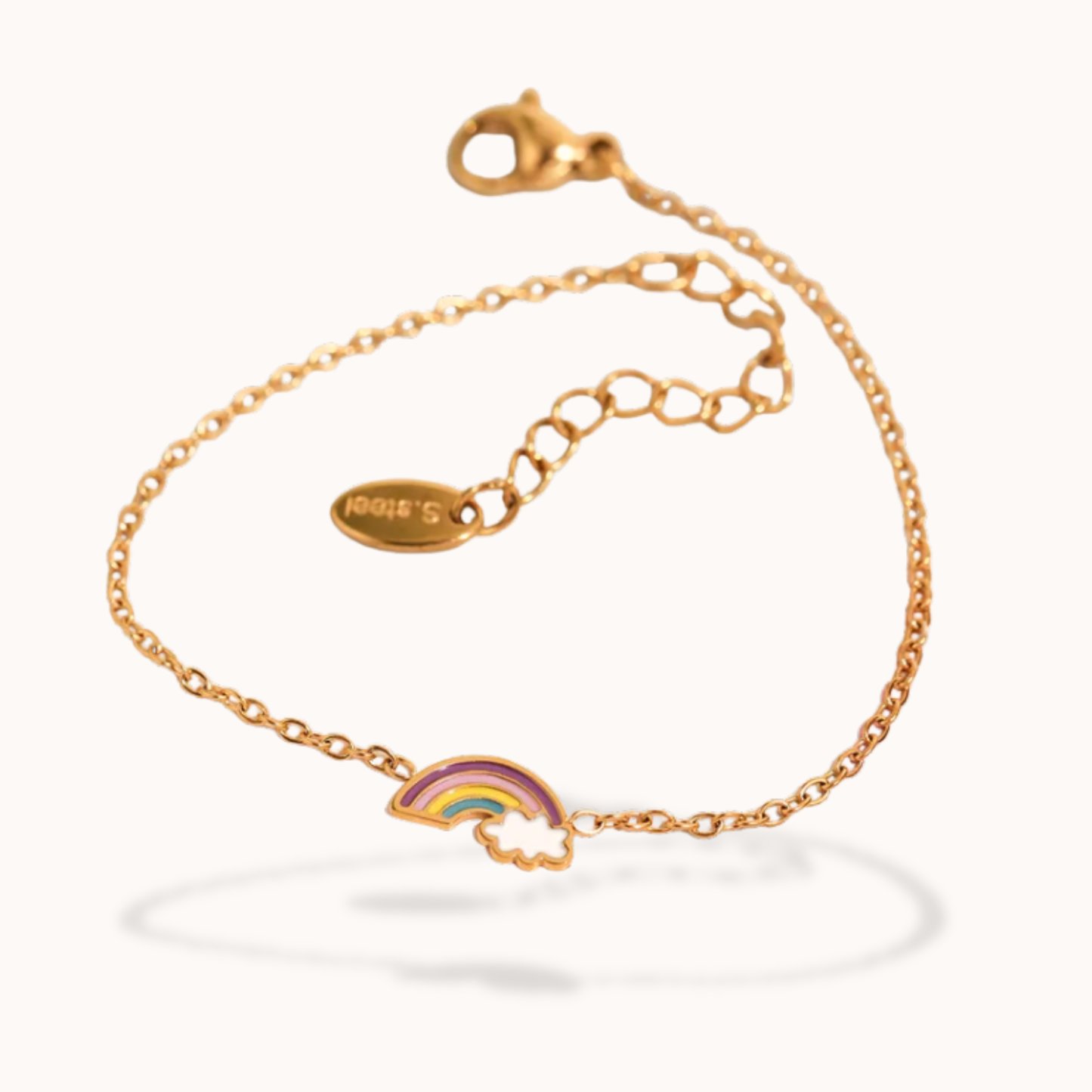 Gold bracelet with a rainbow charm on a white background