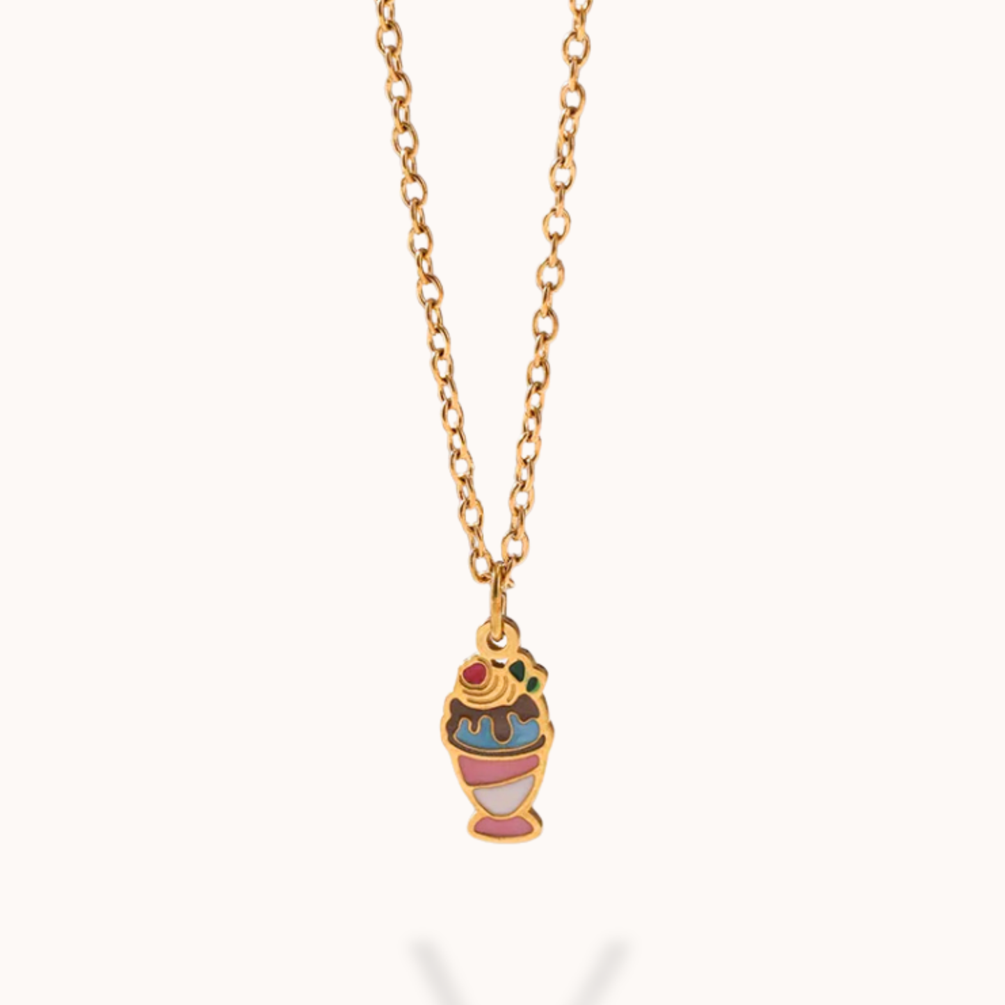 Necklace with a colorful ice cream cone pendant on a gold chain against a white background