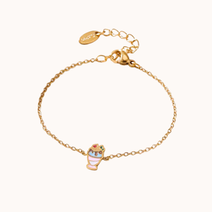 Gold bracelet with a small owl charm on a white background