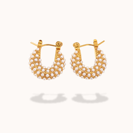 Gold hoop earrings with pearl accents on a white background