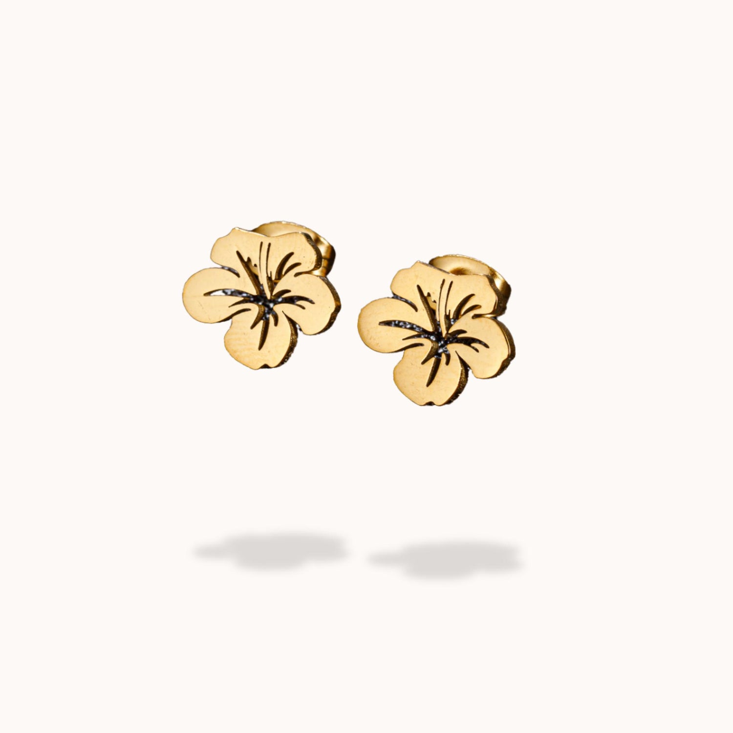 Gold flower-shaped earrings on a white background
