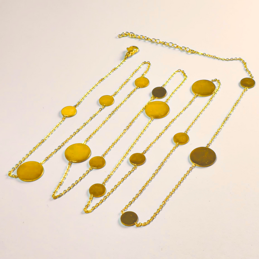 Gold necklace with yellow circular pendants on a light beige background