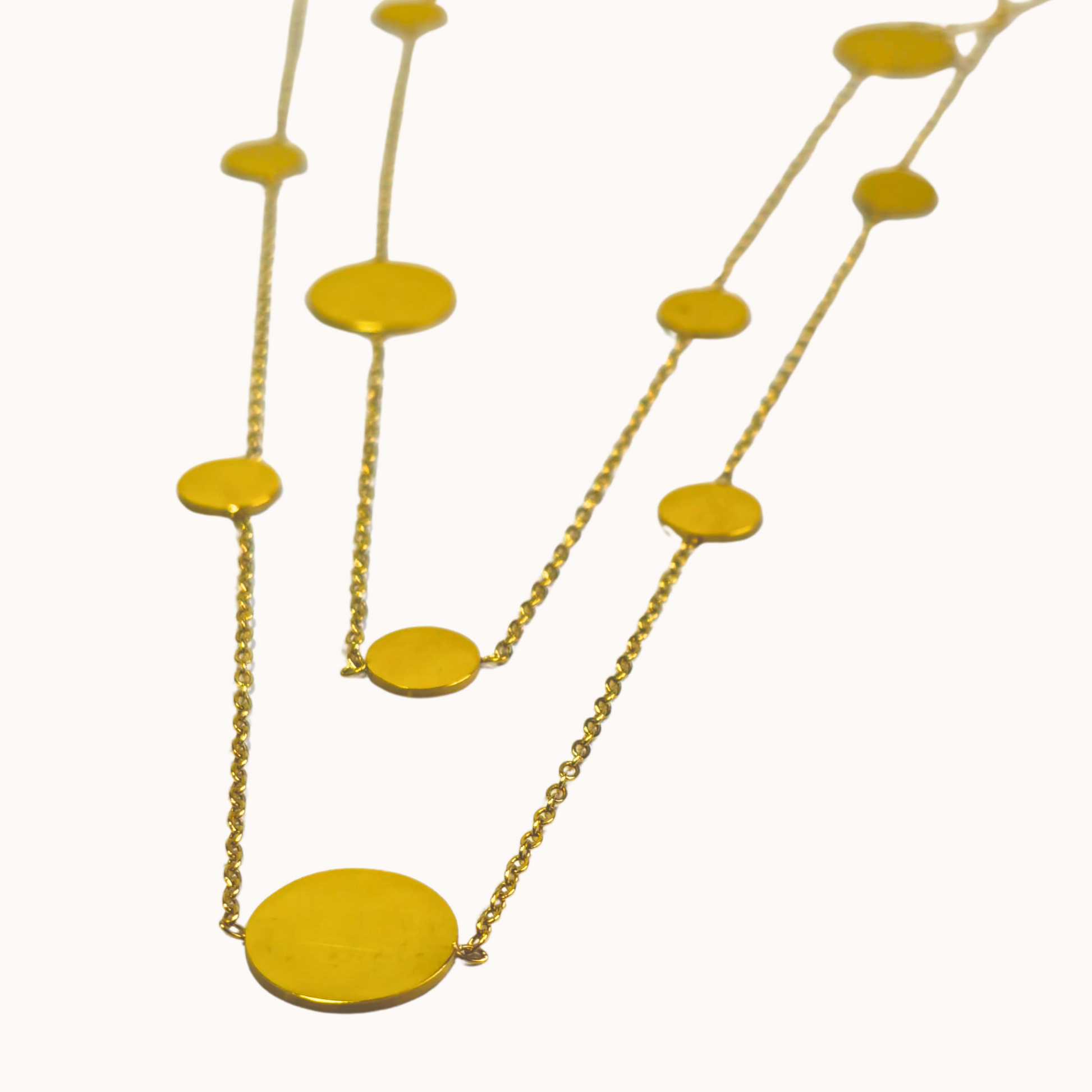 Gold necklace with yellow circular pendants on a white background