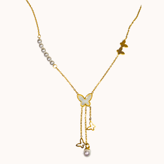 Gold butterfly necklace with pearls on a white background